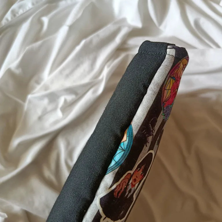 Lateral de la funda de tela acolchada hecha a mano para libro y ebook de Miércoles de Netflix