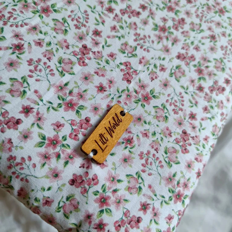 Primer plano del estampado vegetal en tonos rojos fucsias, con textura visible