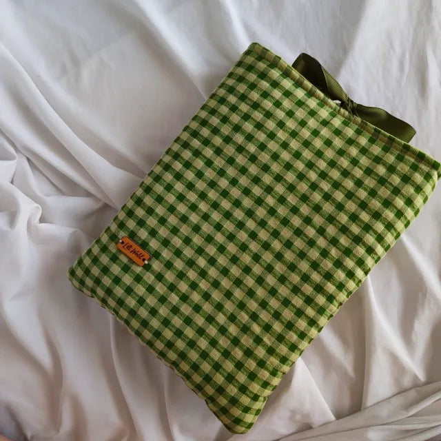 Detalle del sistema de cierre con lazo elástico en funda de tonos verdes.