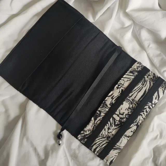 Protege tu libro con una funda de solapa ajustable. Diseño resistente de algodón y loneta, con marcapáginas de cinta incluido