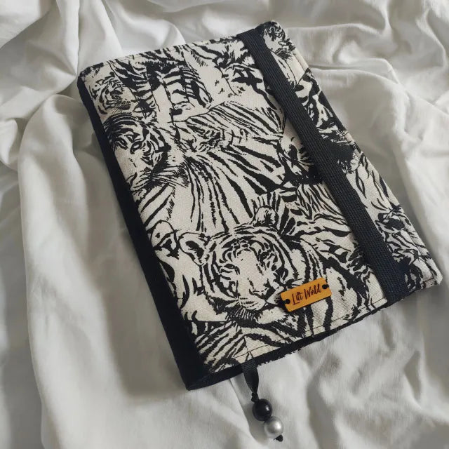 Funda ajustable para libro con estampado de tigres en blanco y negro. Diseño de solapa regulable, ideal para libros de diferentes tamaños
