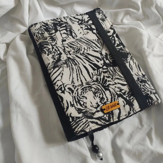 Funda ajustable para libro con estampado de tigres en blanco y negro. Diseño de solapa regulable, ideal para libros de diferentes tamaños