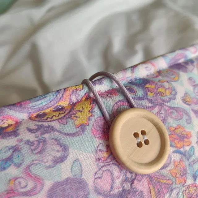 Funda de tela con diseño exclusivo de Pokémon vestidos como personajes de Alicia en el País de las Maravillas. Protección acolchada y cierre seguro.