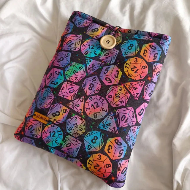 Funda para libro y Kindle con diseño de dados de rol multicolor sobre fondo negro.