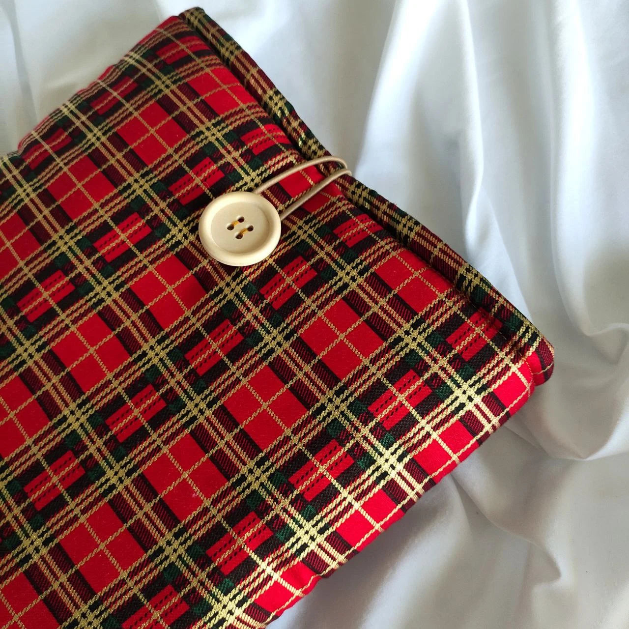 funda verde con dorado y rojo, de cuadros y boton de madera
