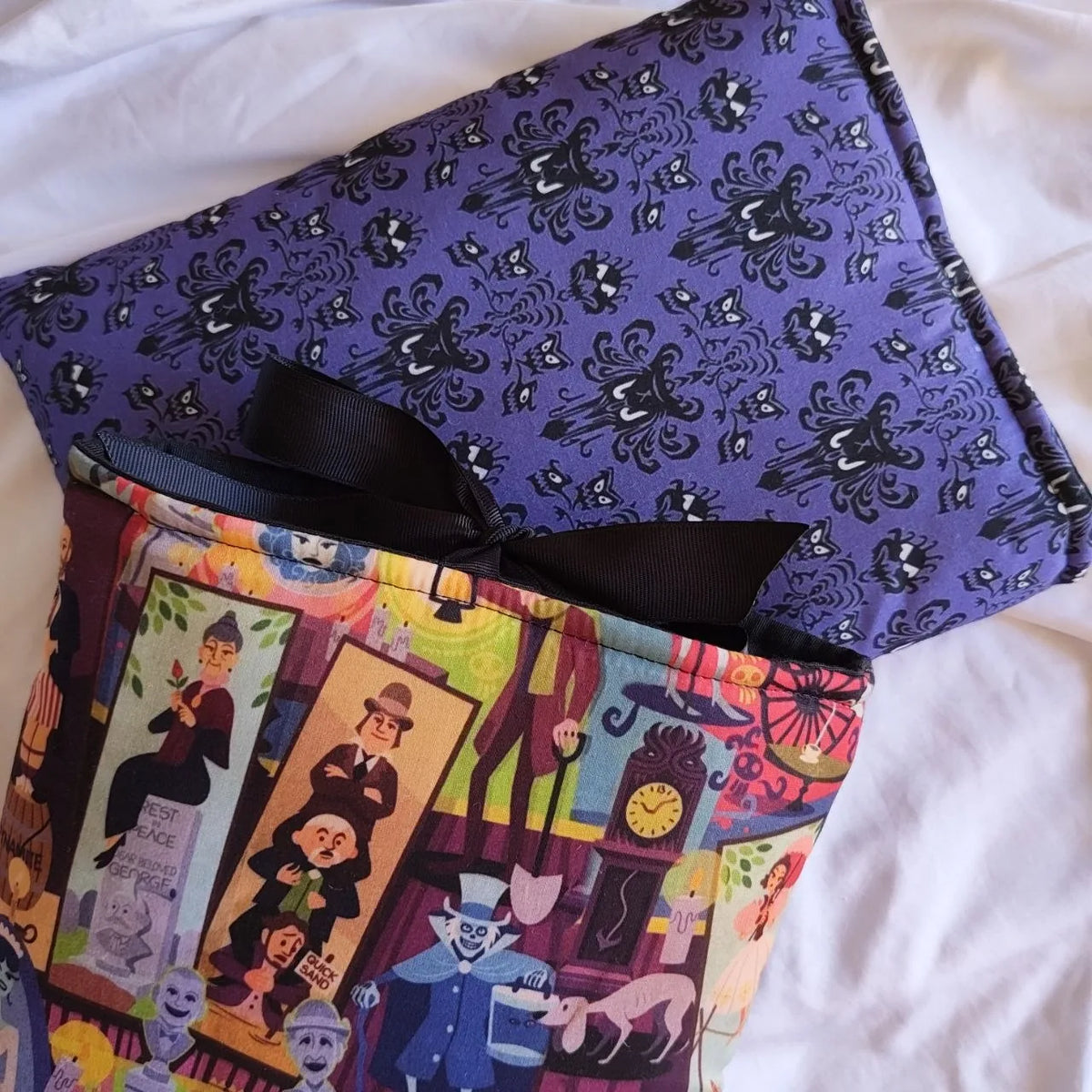 Reverso morado de la funda Mansión Encantada con estampado repetido de murciélagos y figuras oscuras.