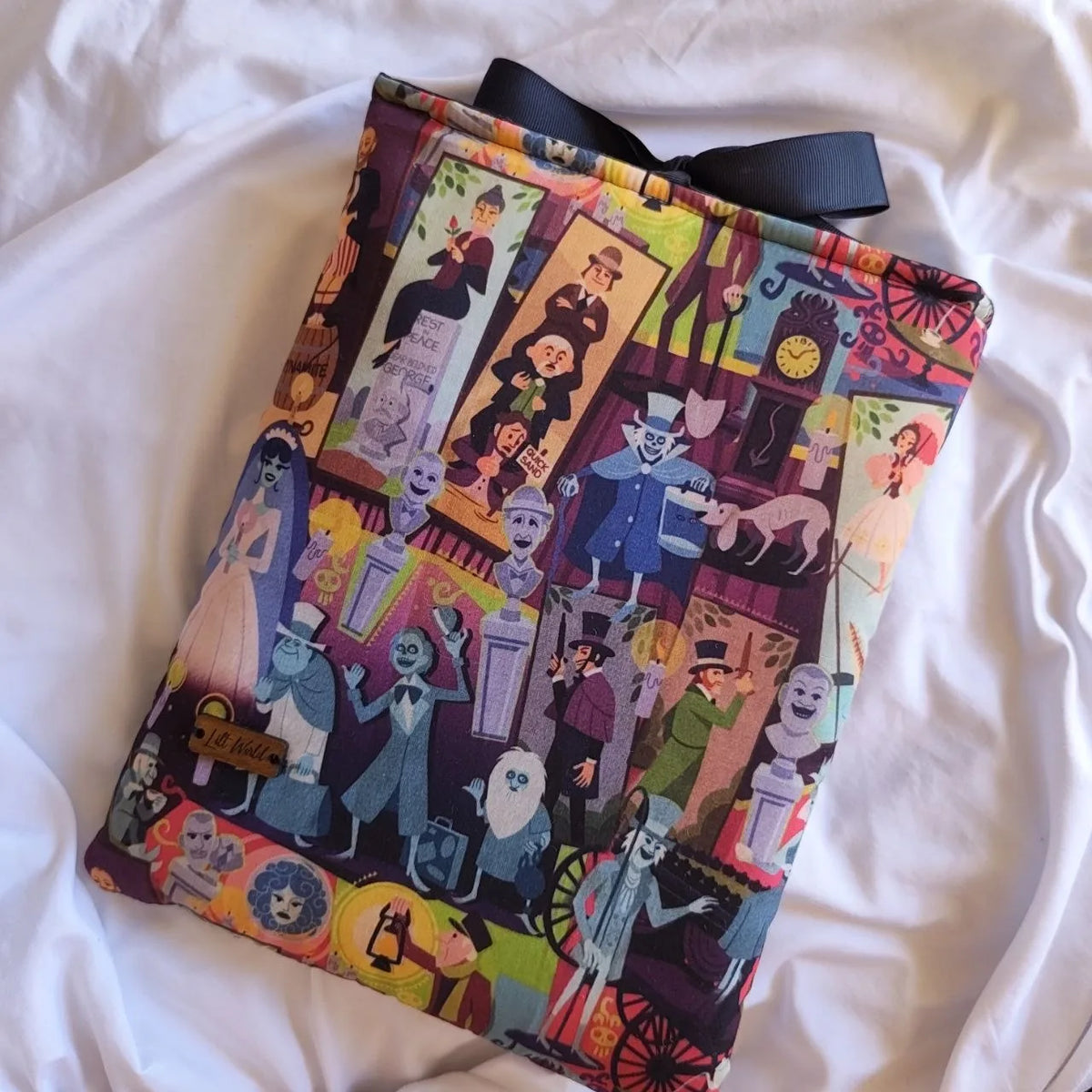 Detalle del estampado de monstruos clásicos y de la etiqueta de madera Lilt World.