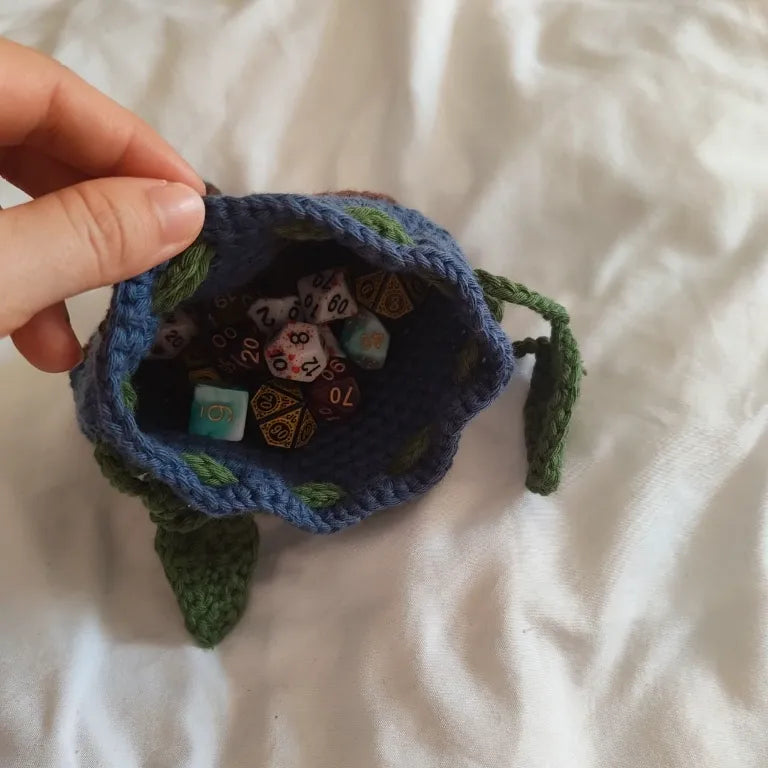 Apertura superior de la funda para dados azul llena de dados poliédricos de resina.