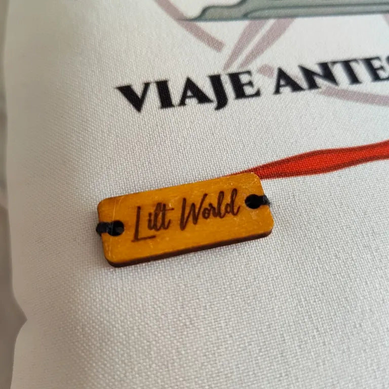 Primer plano de la chapa de madera con el logo de Lilt World cosida sobre la tela de la funda.
