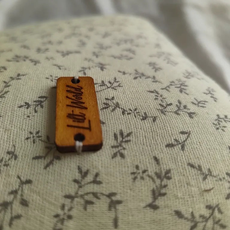 Primer plano de la chapa de madera grabada de Lilt World cosida sobre la tela de estilo botánico.