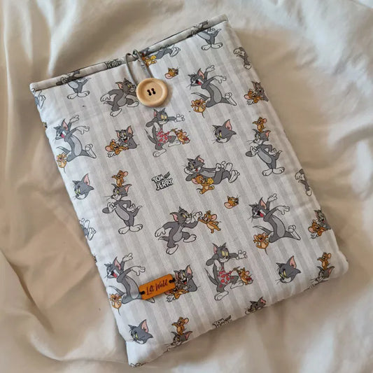 Funda para libro con ilustraciones de Tom y Jerry sobre fondo blanco, vista frontal