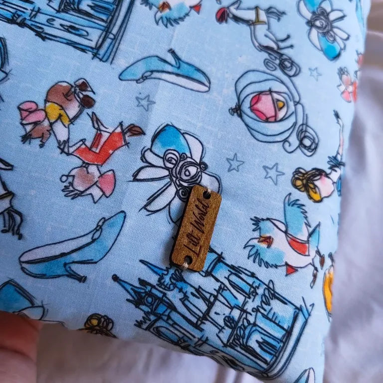 Primer plano del estampado de carrozas y castillos con la etiqueta de madera Lilt World.