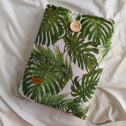 Vista frontal de la funda para libro y Kindle Monsterae con estampado de hojas tropicales verdes.
