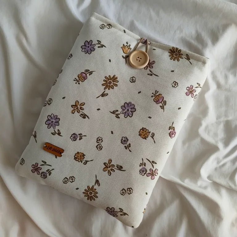Funda para libro y Kindle Nora con estampado de flores moradas y amarillas sobre fondo crema.