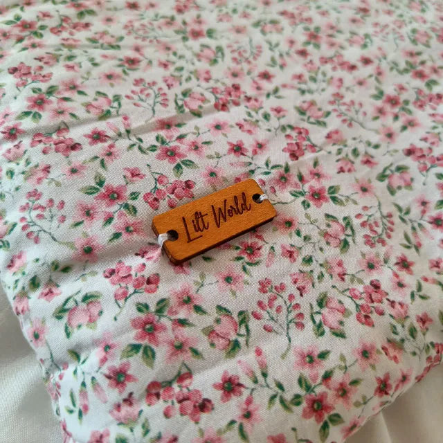 Primer plano del estampado vegetal en tonos rojos fucsias, con textura visible