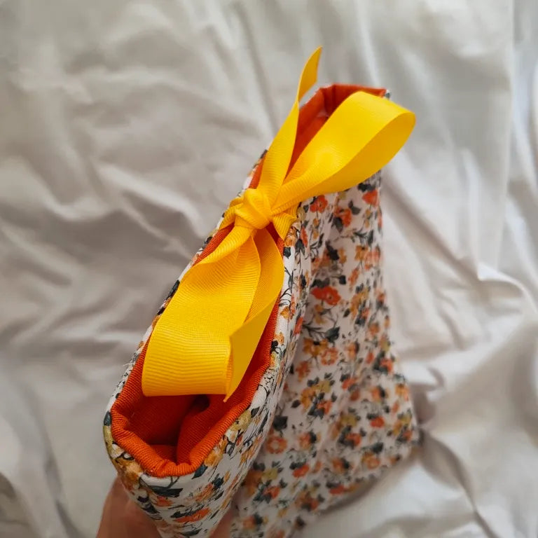 Vista superior en ángulo de la funda para libros y e-reader Solis atada con un elegante lazo amarillo.