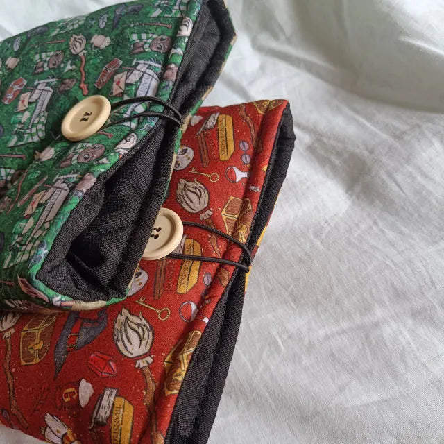 Protección acolchada para libros con diseño de Harry Potter en rojo y verde.