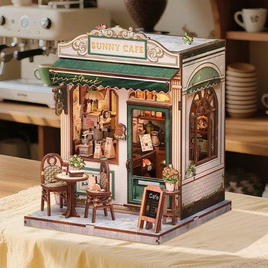 Maqueta terminada de la cafetería en miniatura Sunny Cafe de CuteBee con su iluminación táctil encendida sobre un mantel beige.