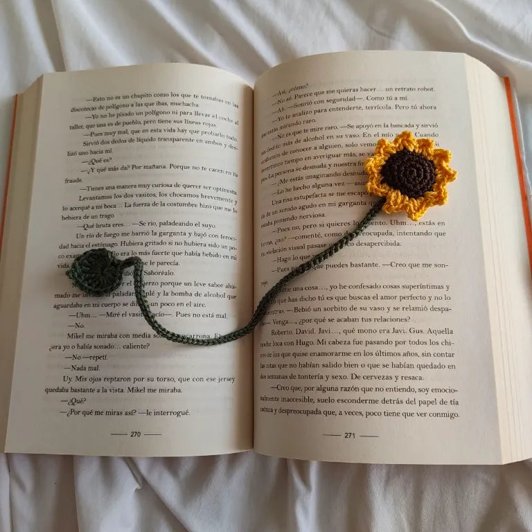 marcapáginas con tallo verde y flor amarilla sobre libro