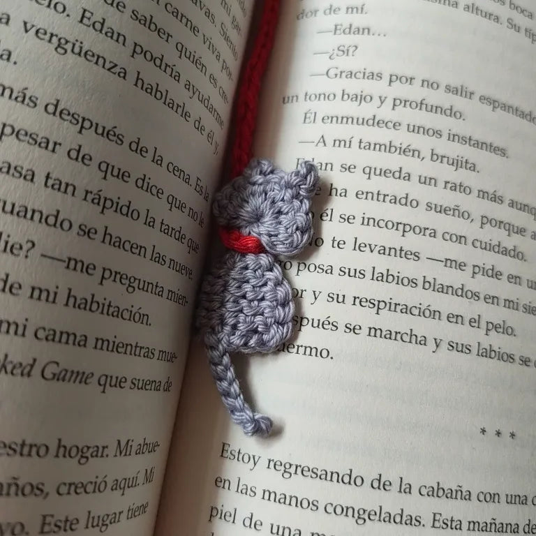 Detalle del gatito gris amigurumi de crochet marcado en la página inferior del libro.