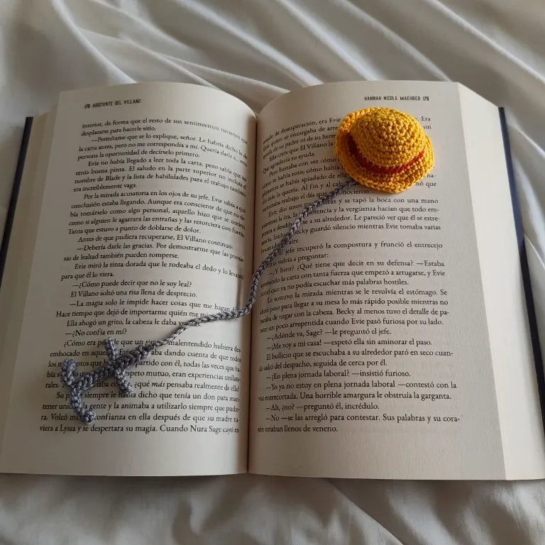 marcapáginas de crochet con sombrero de pirata sobre libro abierto