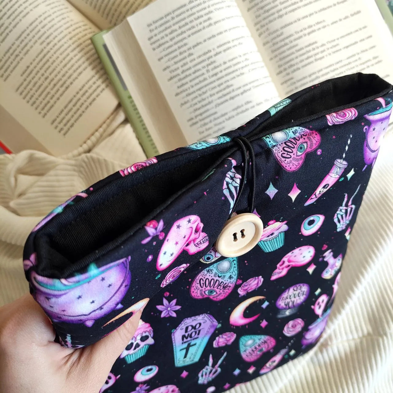 funda de tela acolchada para proteger los libros y kindle. Color negro con tonos rosas.