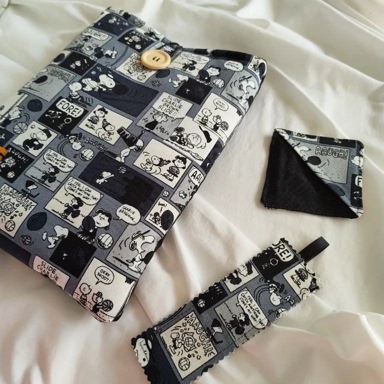 Conjunto de accesorios de lectura Peanuts con funda acolchada, marcapáginas de tela rectangular y marcapáginas esquinero con diseño de cómic de Snoopy.