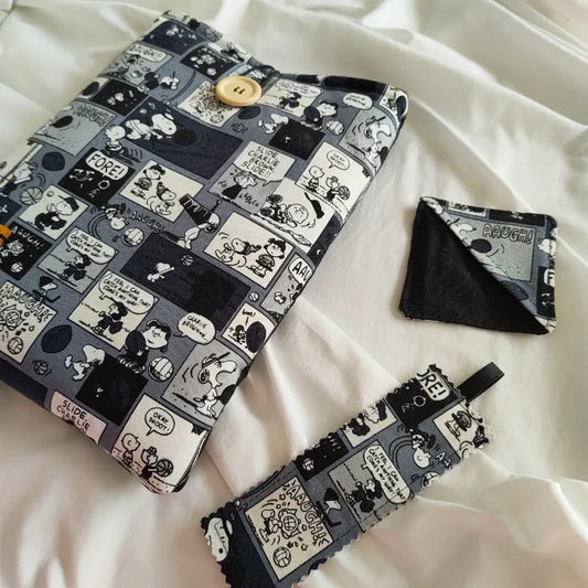 Conjunto de accesorios de lectura Peanuts con funda acolchada, marcapáginas de tela rectangular y marcapáginas esquinero con diseño de cómic de Snoopy.